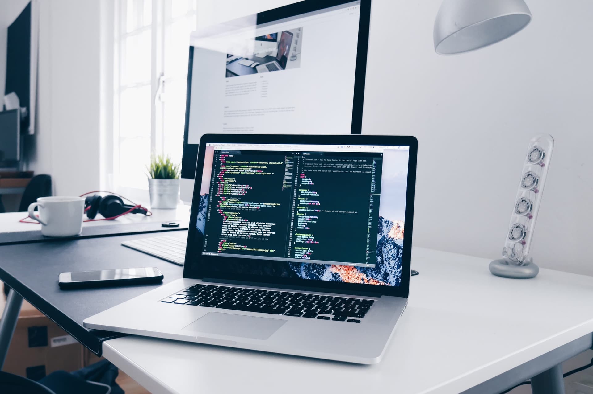 A developer workstation showing code on a laptop.